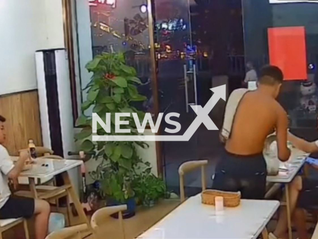 A man steals customers' food and drinks in a restaurant in Hezhou city, Guangxi province, China, on Saturday, Aug. 20, 2022. The restaurant owner said that he gave customers another meal for free. Note: This picture is a screenshot from the video (116775683/AsiaWire)