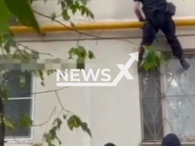 Police rescue a boy from a window in a building in Moscow, Russia in undated footage. Note: This picture is a screenshot from the video (Ministry of Internal Affairs of Russia/Newsflash).