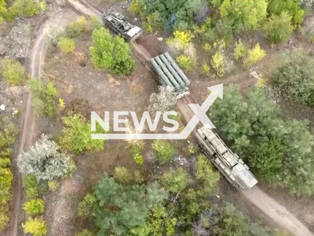 Russian military vehicles go down the road in a forest area in Ukraie in undated photo. The crews of the S-300V anti-aircraft missile systems (AAMS) of air defense of the Central Military District worked to cover the Russian group of troops and settlements from Ukrainian air attack weapons. Note: This picture is a screenshot from the video (@function.mil.ru/Newsflash).