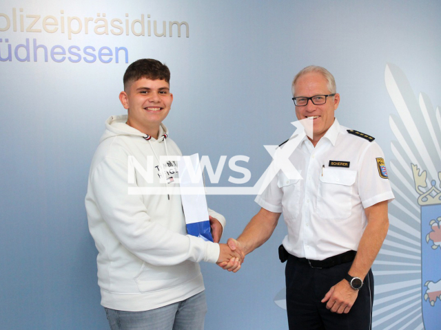 Luis Martins, 14, and Chief Police Director Hartmut Scherer pose in undated footage. The young man from the town of Griesheim in the Darmstadt-Dieburg district in Hesse, Germany rescued a five-year-old boy from drowning on Sunday, June 19, 2022. Note: Licensed content. (Polizeiprasidium Sudhessen/Newsflash)