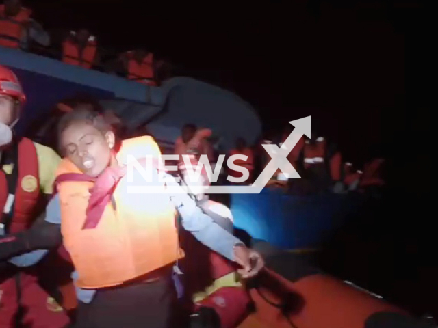 The members of Open Arms help migrants during the rescue in the central Mediterranean sea, on Sunday, Sept. 18, 2022. The 294 migrants were in a boat for several days and went for 2 days without water or food and were found after a 24 hour search. Note: Picture is a screenshot from a video (Open Arms/Newsflash)