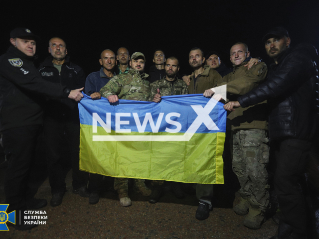 Ukrainian soldiers pose with the Ukrainian flag after being released from the Russian captivity in Ukraine in undated photo. Ukraine returned 215 soldiers from captivity, half of them soldiers of the "Azov" regiment. Note: Security Service photo. (Security Service of Ukraine/Newsflash)