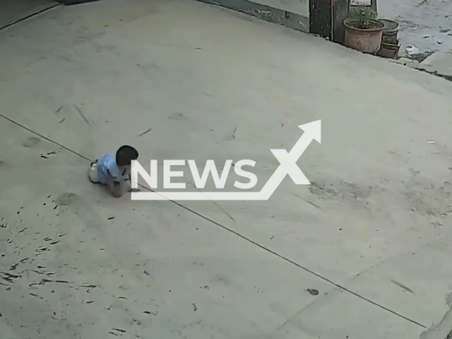 One-year-old baby crawls outside house towards street in Zhenping County, Henan in China in undated footage. It was then spotted by a neighbour who brought her back home. Note: Picture is a screenshot from a video (hanhanzhubao511/AsiaWire)