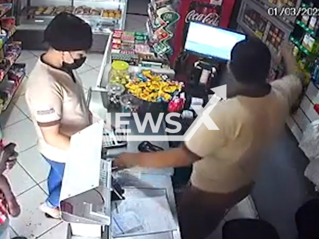 Man robs a bakery in Londrina, Parana in Brazil, with a child in his hands. Note: This picture is a screenshot from the video (Newsflash).