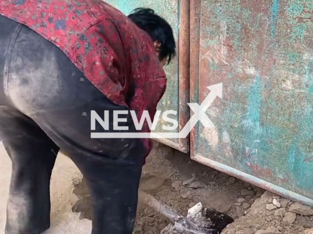 A 68-year-old woman digs a hole to enter home after forgetting keys in Zhoukou, Henan in China, undated. The granddaughter, Ms. Xia, said that her grandmother was deaf and had a poor memory. Note: Picture is a screenshot from a video (xia725745/AsiaWire)