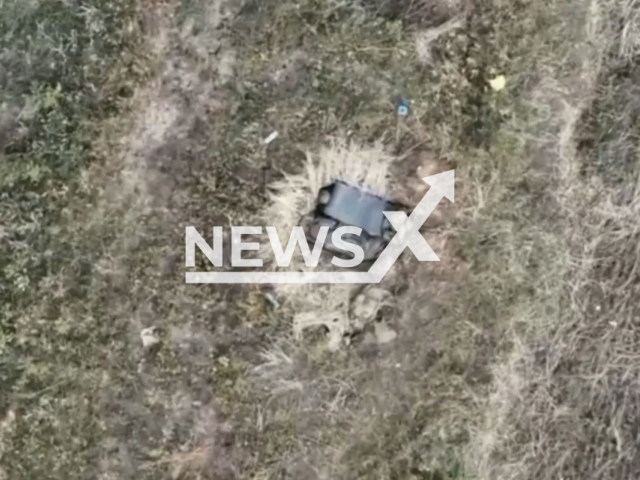 Two Russian soldiers hide in their dugout in a field area in Ukraine in undated photo. Ukrainian fighters of the 10th separate mountain assault brigade detected and destroyed Russian invaders with the help of a drone. Note: Photo is a screenshot from a video.(@10brygada/Newsflash)