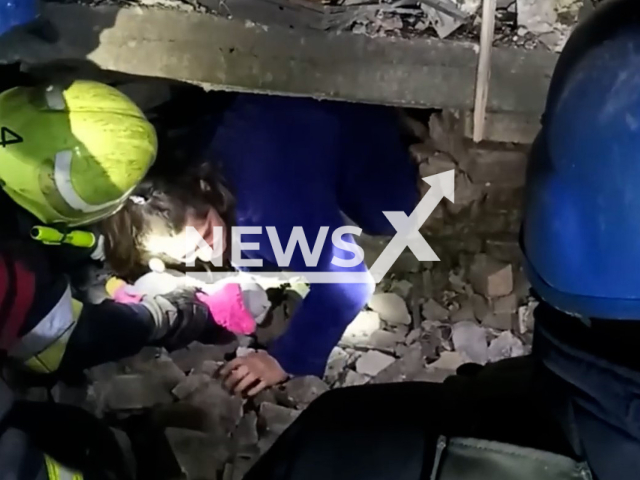 Girl climbs out from destroyed building holding hand of rescuer in Zaporizhzhia, Ukraine, Wednesday, Oct. 12, 2022. Ukrainian rescuers save a family under destroyed building as a result of Russian rocket attacks at night in Zaporizhzhia. Note: Picture is a screenshot from a video. (@MNS.GOV.UA/Newsflash)