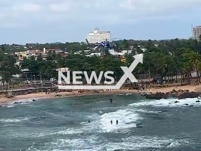 A 48-year-old English tourist hangs from a helicopter,  in Salvador, Brazil, on Tuesday, Oct. 11, 2022.
He was rescued by a helicopter from the Bahia Military Police Air Group (GRAER) after getting stuck on rocks in the sea Note: Picture is a screenshot from a video. (GRAER/Newsflash)