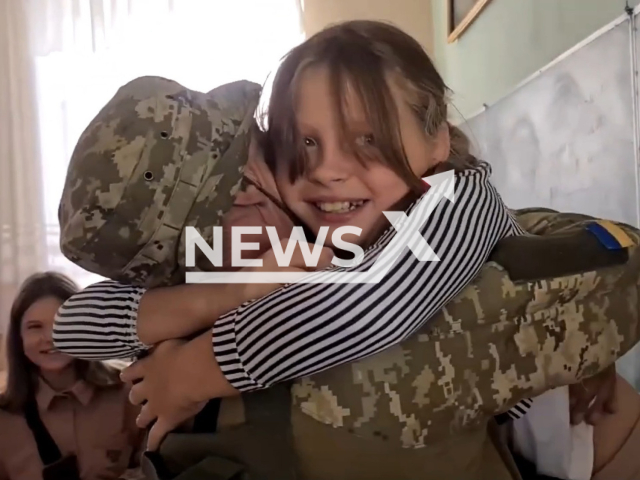 Border guard Mykola hugs his daughter Maria in her school classroom in Odesa in undated photo. Mykola performed combat mission in the Zaporizhzhia direction and returned to Odesa after rotation. Note: Picture is a screenshot from a video (@dpsu.gov.ua/Newsflash)