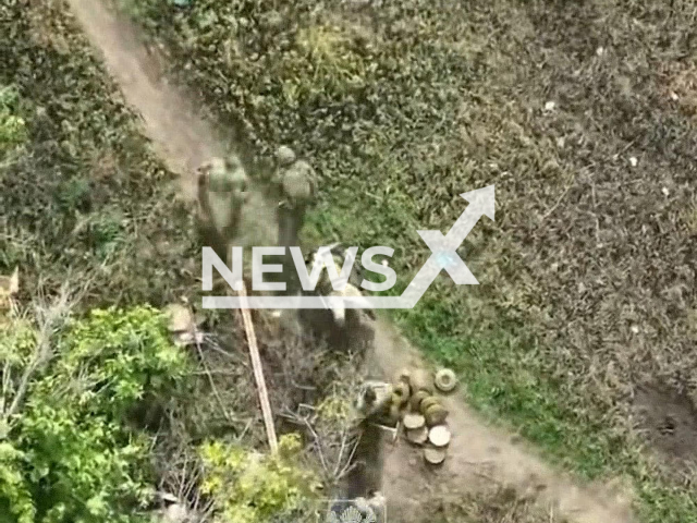 Russian soldiers transport their wounded colleague on a wheelbarrow near forested area in the east of Ukraine in undated photo. Fighters of 2nd mechanized battalion of hetman Bohdan Khmelnytsky independent Presidential Regiment shot at positions of Russian army. Note: Picture is a screenshot from a video (Presidential Regiment/Newsflash)