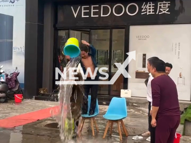 Workers who did not complete task punished with water over head in Yichang, China. Note: Picture is screenshot from a video (850863440/AsiaWire)