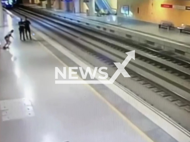 Police officers save  a 39-year-old  woman as she attempts to throw herself onto the train tracks, Puerto Real, Spain, undated. She was transferred to the hospital to be treated by the medical services. Note: Photo is a screenshot from the video (Newsflash)