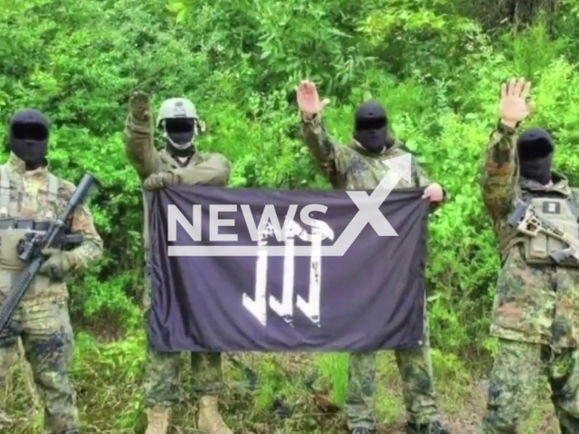 Picture shows  Antonio Pennelli, 23, and other unidentified people in military  dress giving a Nazi salute and showing the flag of their organization, undated.  He was  charged for enlistment for terrorism and propaganda and incitement to crime on grounds of racial, ethnic and religious discrimination when he was arrested in in Bari, Italy, on Thursday, Oct. 27, 2022. Note: Police photo (@poliziadistato/Newsflash)