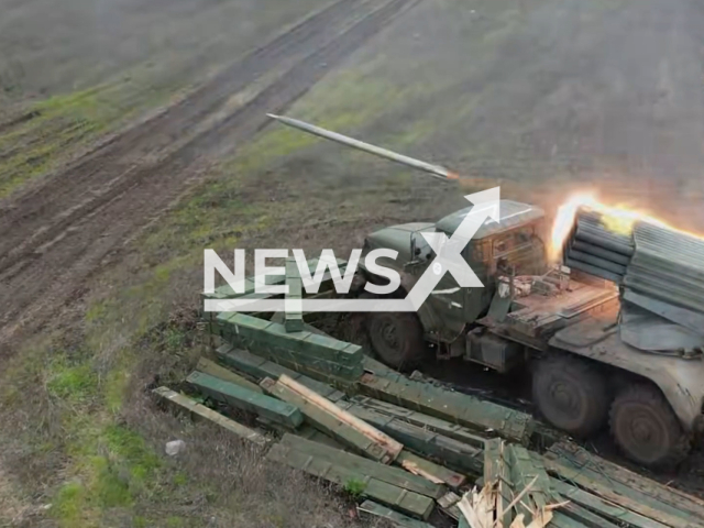 GRAD with Z letter on it launches rockets in a field area in Ukraine in undated photo. DPR soldiers watch at Ukrainian positions from drones and give info to artillerymen for shooting from GRAD self-propelled multiple rocket launcher. Note: Picture is screenshot from a video (@nm_dnr/Newsflash).