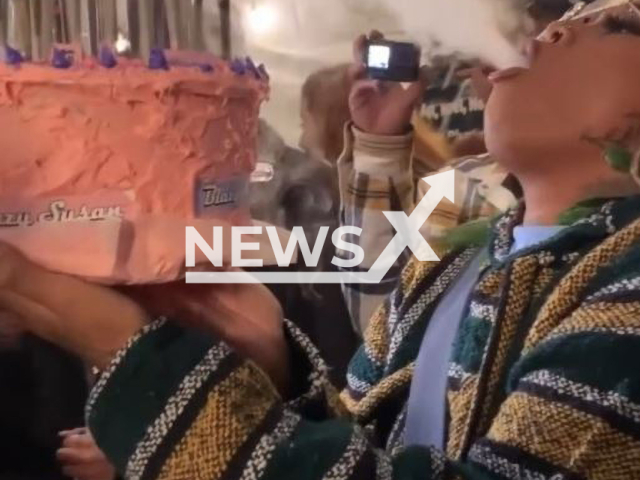 Rapper and cannabis marketer, Alicia Goku, 29, exhales smoke, from a cake, at an event called Backyard Boogie, in Denver, Colorado, in undated footage. According to Alicia, the cake was baked by @earthsmokesalot2. Note: Picture is screenshot from a video (@izzy_blazee; @aliciagoku_; @earthsmokesalot2/Newsflash).