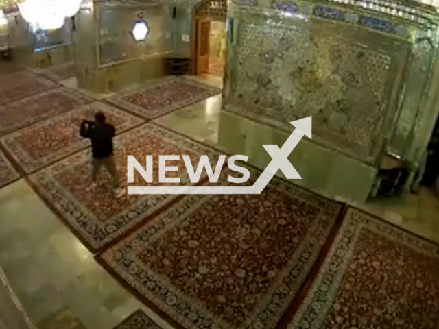 A gunman shoots at people at Shah Cheragh mosque, a Shia pilgrimage site in Shiraz, southern Iran, Wednesday, Oct. 26, 2022. At least 13 people were killed in the mass shooting. Note: This picture is a screenshot from the video (Newsflash).