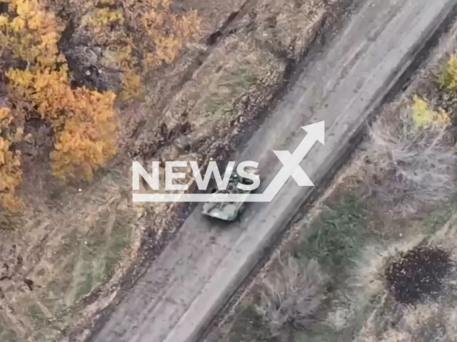 Russian tank with bodies on it moves down the road near treeline in a field area in Ukraine in undated photo. Drone of the Airborne Assault Troops of the Armed Forces of Ukraine detected Russian armored vehicle driving at speed with bodies of died soldiers on top of it. Note: This picture is a screenshot from the video (@www.dshv.mil.gov.ua/Newsflash).