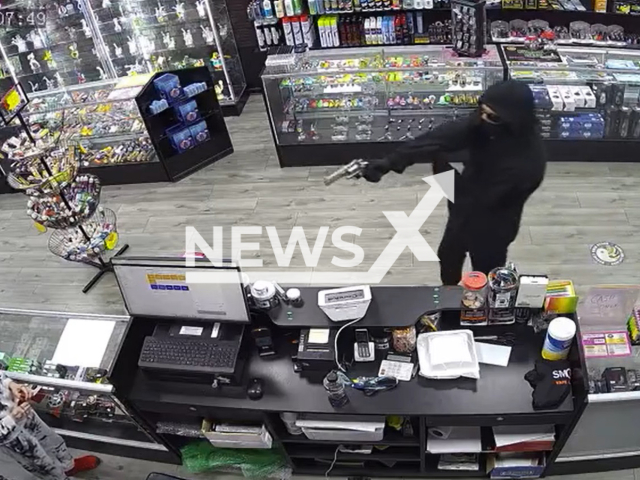 Brandon McMahon, 18, points a gun at a clerk  during the attempted robbery  at a vape store in Canton, Georgia, on Thursday, Nov. 3, 2022.
He claims he was pulling a prank when he tried to rob the shop in a mask with a gun. Note: Photo is a screenshot from a video. (Newsflash)