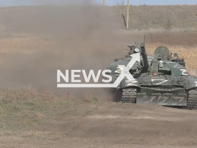 Pro-Russian soldier rides tank with Z letter on it in a field area in the Zaporizhzhia region, Ukraine in undated photo. People's Militia of the DPR showed work of the repair battalion fixing military equipment. Note: Picture is a screenshot from a video (@nm_dnr/Newsflash)