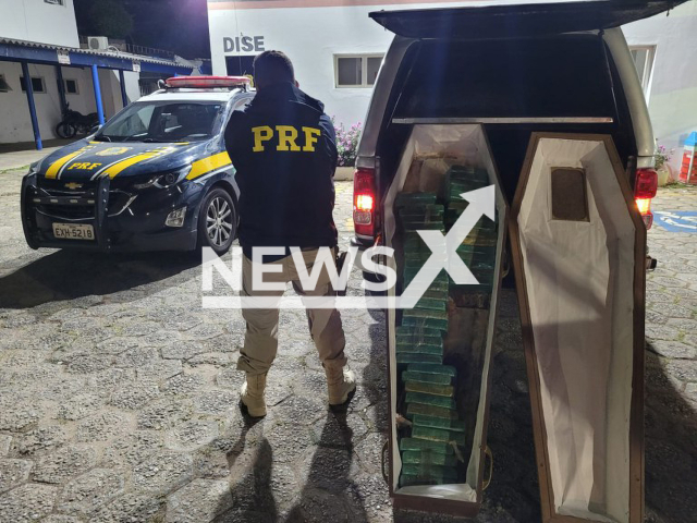 Police officer poses with the  50 kilogrammes of crack cocaine found in a coffin on Fernao Dias highway, in Vargem, Brazil, on Tuesday, Nov. 8, 2022. The driver was arrested for drug trafficking. Note: Police photo. (@prf_sp/Newsflash)