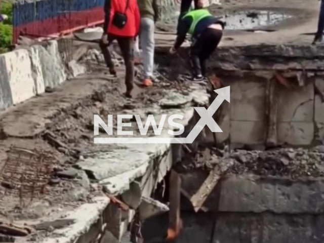 Mykhailo Puryshev, 36, who resides in Kyiv, climbs down a wall in order to save a dog, in Kupyansk, Ukraine, in October, 2022. Mikhail successfully rescued the dog. Note: Photo is a screenshot from the video (@mrgunich/Newsflash)