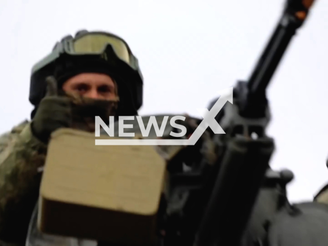 Russian soldier gives the thumbs up sign while on a Russian tank rolling through city along with artillery units in Ukraine. Note: This picture is a screenshot from the video. (Ministry of Defense of Russia/Newsflash)