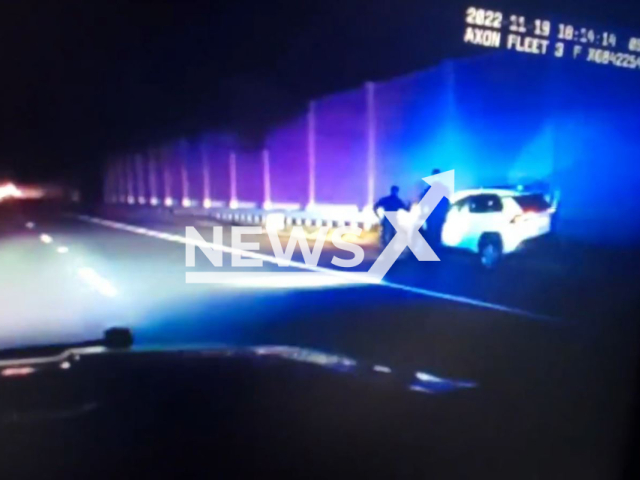 Cops walk by the slow-moving vehicle with its drunk and unconscious driver sitting behind the wheel in South Brunswick Township, New Jersey, USA, undated. It was determined that the driver had been intoxicated and got arrested. Note: The photo is a screenshot from a video(@SoBrunswickPD/Newsflash).