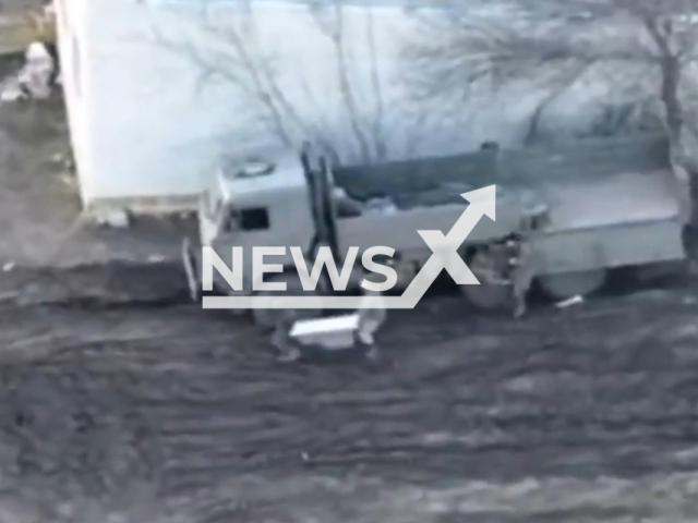 Russian soldiers carry bathtub from their military truck in a residential area of Ukraine. The footage was obtained from the AFU StratCom on Wednesday, Dec. 7, 2022. Note: Picture is a screenshot from a video (@AFUStratCom/Newsflash)