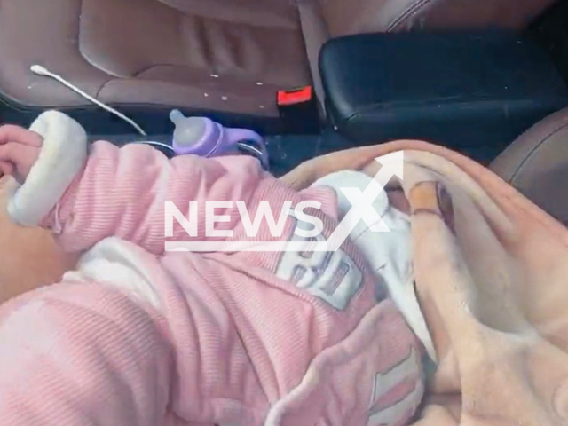 Police rescue crying baby locked in car as parents left to watch performance in Qiandongnan, China. Note: Picture is a screenshot from a video (QDN_TP/AsiaWire)