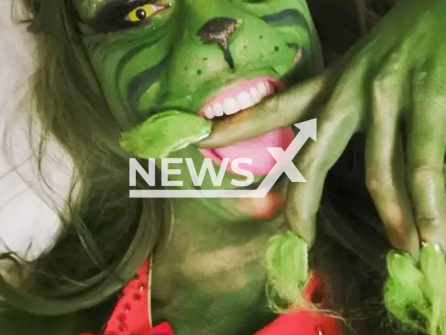 Eve Champagne, 38, poses in undated photo. She dressed up as the Grinch and posed in front of a fireplace in the city of Hamburg, Germany in December 2022. Note: Private photo. (@eve_champagne/Newsflash)