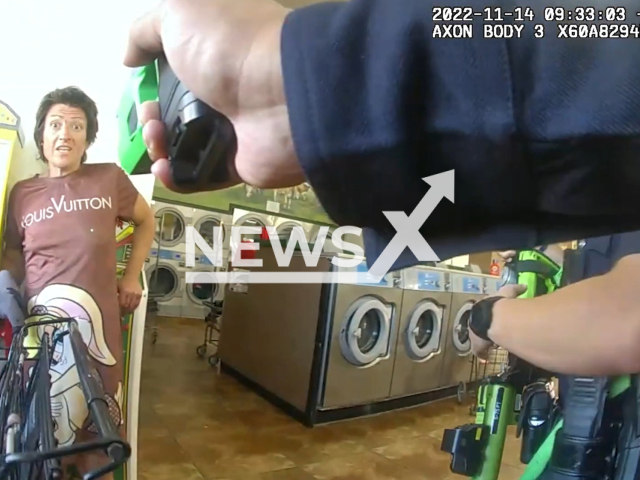 A police officer points a gun at the suspect before the arrest in  Los Angeles, California, USA on Monday, Nov. 14, 2022. After the suspect was transported to a local hospital, she was treated, released and cleared for booking. Note: This picture is a screenshot from the video. (Los Angeles Police Department/Newsflash)