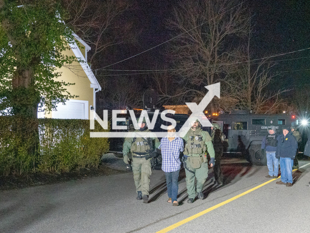 Police officer escort the handcuffed suspect in Cohasset, Massachusetts, USA,  on Sunday, Dec. 18, 2022. The man was arrested  after allegedly trying to break into the   police station with a chainsaw then barricading himself with two small children in his home for several hours.
Note: Police photo. (@CohassetPolice/Newsflash)