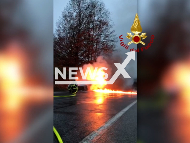 Italian firefighters battling a flaming vehicle on the side of a road in Italy on Friday, Dec. 16, 2022. It reportedly took the effort of two fire brigade teams from the Forli-Cesena Province, located in northern Italy, for the raging fire to be contained. Note: Picture is screenshot from a video. (@vigilfuoco/Newsflash)