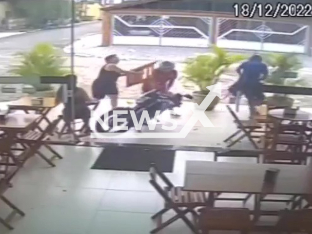 A woman hitting a thief with a chair in Praia Grande, Brazil, on Sunday, Dec. 18, 2022. The men stole her and her pregnant friend's cell phones, they have not yet been identified.  Note: Picture is a screenshot from a video (Newsflash)