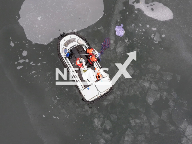 Officers rescue a swan that got stuck to the newly formed ice on a lake in Oakland County, Michigan, USA on Thursday, Dec.22, 2022. The swan was given a lift back to shore and turned over to Oakland County Animal Control to receive treatment for a suspected leg injury. Note: Picture is screenshot from a video (Oakland County Sheriff/Newsflash).