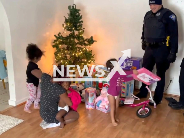 Police officers bring Christmas gifts to kids whose house was robbed on Christmas Eve in  South Bend, Indiana, USA on Sunday, Dec. 25, 2022. The donated gifts were left over from a toy drive organized by the South Bend FOP Lodge #36 Santa's Elficers program. Note: Photo is a screenshot from a video.(South Bend Police Department/Newsflash)