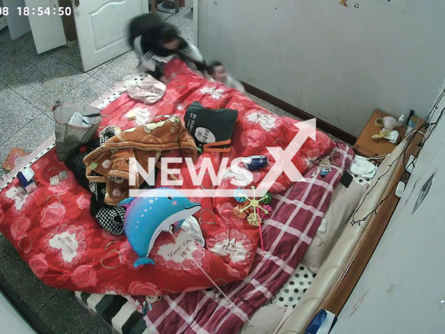 Mother catches the baby about to fall from bed in Fuyang, China. Note: Picture is a screenshot from a video (75556378/AsiaWire)