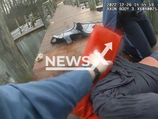 The image shows officers saving a juvenile who had jumped into a frozen creek to save his friend in Maryland, USA on Monday, Dec. 26, 2022.  The boy was taken to the hospital by ambulance for a checkup and was later given the all clear. Note: This picture is a screenshot from the video. (@AACOPD/Newsflash)