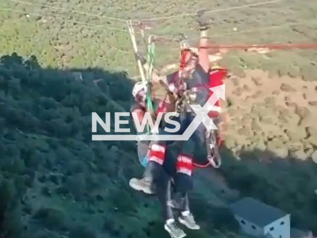 A firefighter rescues a woman stuck on a zip line of the Castillo del Aguila in Gaucin, Spain. The woman was not injured. Note: Picture is a screenshot from a video (@diputacionMLG/Newsflash)