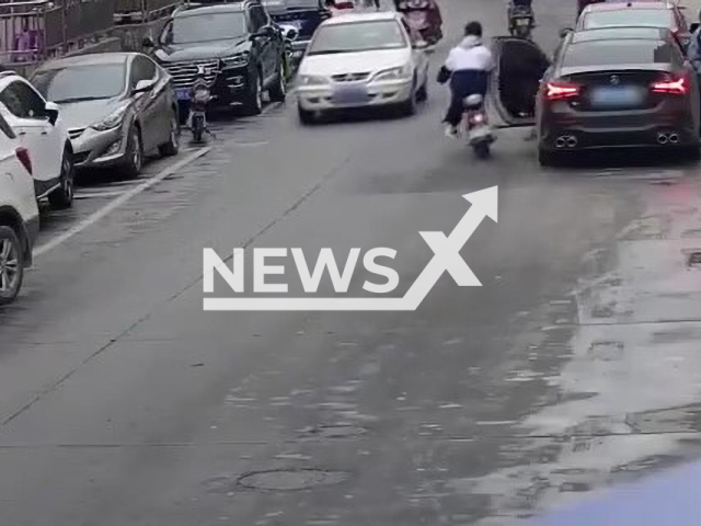 Man opens car door and hits motorbike rider sending him under the wheels of another moving car in Dong'an County, Yongzhou in China, undated. The man's injuries were not life-threatening. Note: Picture is screenshot from a video (Hunan Traffic Police/AsiaWire)