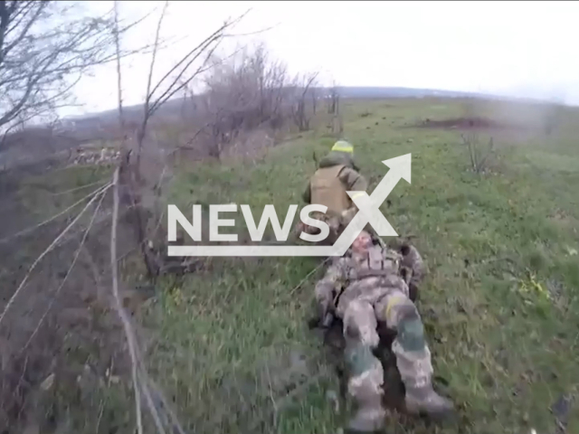 Ukrainian paratrooper carries his wounded colleague officer under fierce fire in the Bakhmut area in Ukraine in undated footage. The footage was released by the 71st yager brigade of the Ukrainian Airborne Assault Troops on Thursday, Jan. 12, 2023.   Note: Picture is a screenshot from a video. (@71brigade/Newsflash)