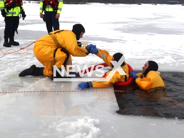 Firefighters with the Fort McCoy Directorate of Emergency Services Fire Department's dive team practice a surface ice rescue scenario at a frozen lake in Wisconsin, USA, on Wednesday, Jan. 11, 2023. The divers were covering depths of up to 15 feet completing several types of rescue scenarios under the guidance of fellow firefighters. Note: This picture is a screenshot from the video. (DVIDS, Fort McCoy Public Affairs Office/Newsflash)