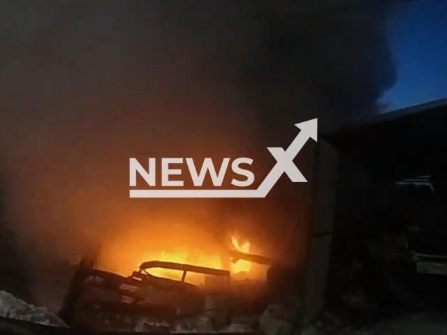 Emergency crew helps a man salvage his Rover from a burning garage after a fire broke out due to a gas explosion in Russia, undated. After assessing the situation, police officers, with the help of dozens of locals, towed away the car that was already beginning to melt from the scorching heat. Note: Picture is screenshot from a video.(Video news of the police of the Orenburg region/Newsflash)