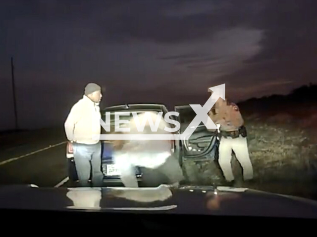 Police officer arresting a suspect during  a traffic stop in  Texas, USA, undated. The driver and two passengers were apprehended, and the two migrants were referred to the US Border Patrol. Note: Picture is screenshot from a video.(@LtChrisOlivarez/Newsflash)