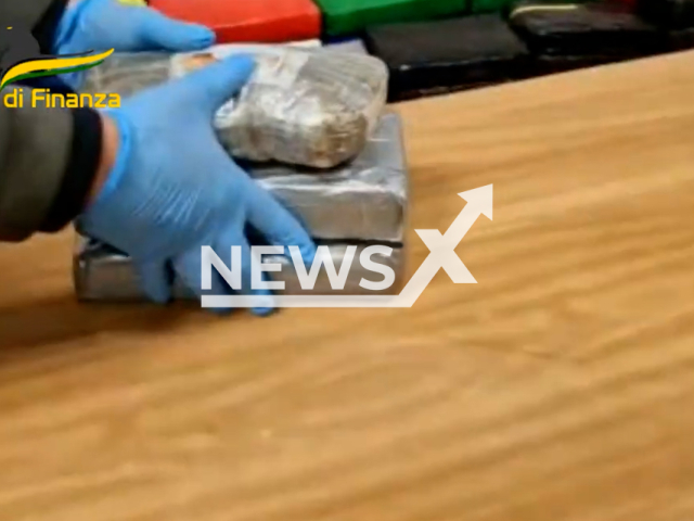 Officer holds a cocaine package in undated footage. Guardia di Finanza seized over a ton of cocaine from a Chinese multipurpose cargo ship, at the port of Savona, in Italy. Note: Photo is screenshot from a video. (GuardiaDiFinanza/Newsflash)