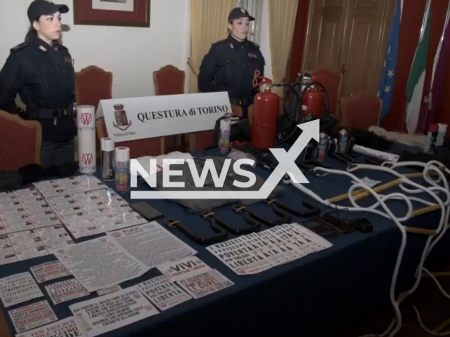 Two police officers pose after the State Police's operation against Novax, in Turin, Italy, in undated footage. The police denounced 6 people with clean records, aged between 41 and 53. Note: Picture is screenshot from a video. (poliziadistato/Newsflash)