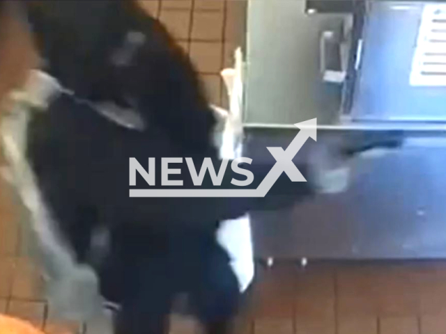 One of the suspects aims his gun during the robbery at Popeye's Chicken, in Memphis, Tennessee, on Sunday, Jan. 15, 2023. The two suspects fled from the scene on foot. Note: Picture is screenshot from a video. (Memphis Police Department/Newsflash)