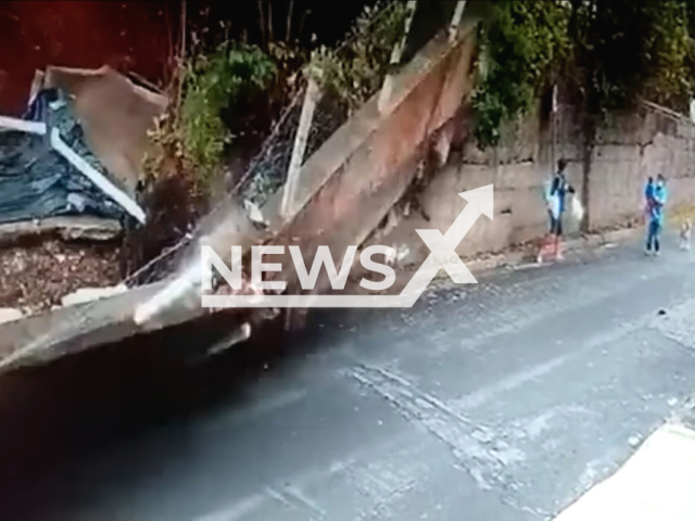 A wall collapses as couple and child are  in Pocos de Caldas, Brazil, on Saturday, Jan. 21, 2023. Local authorities said they had found it at  risk of falling but because of the rains, the soil was soaked, and the retaining wall ended up collapsing. Note: Photo is a screenshot from a video. (Newsflash)