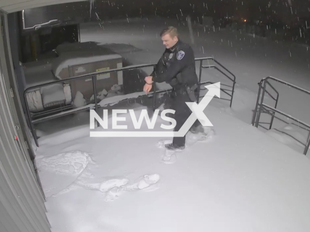 Police Officer Carter Jamieson walks in the snow in Viroqua, Wisconsin, on Wednesday, Jan. 18, 2023. The Officer got a pile of snow dumped on his head after closing a door. Note: Picture is a screenshot from a video (Viroqua Police Department/Newsflash)