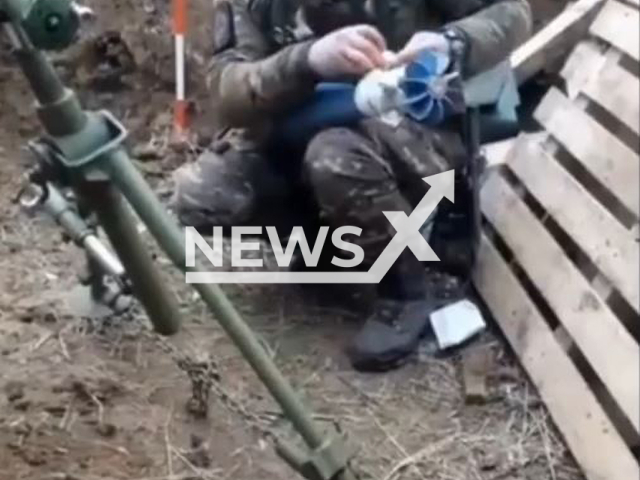 Ukrainian soldier wraps rocket into white flag in Ukraine in undated footage. The footage was released by the Zaporizhzhia separate territorial defense brigade on Sunday, Feb. 5, 2023. Note: Picture is screenshot from a video. (@110tro/Newsflash)